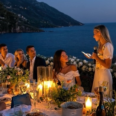 A speech by candlelight at the evening wedding table above the sea